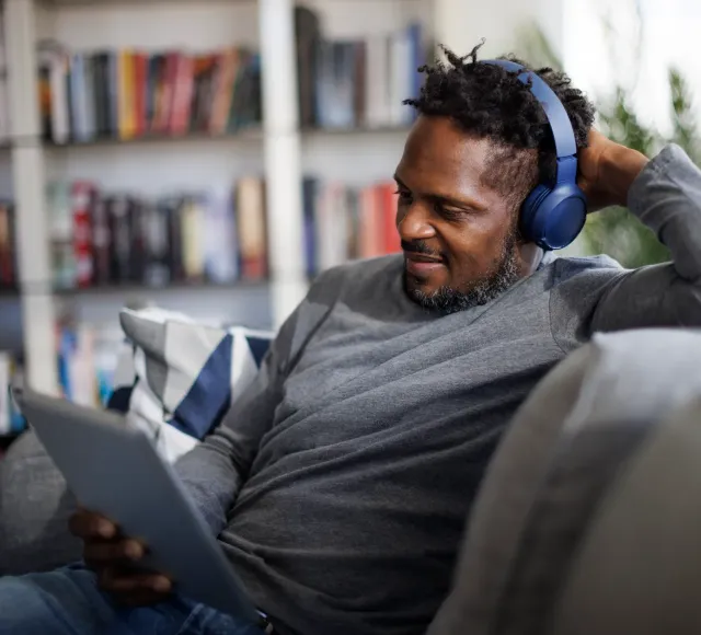 Man using a tablet with headphones - Hero image