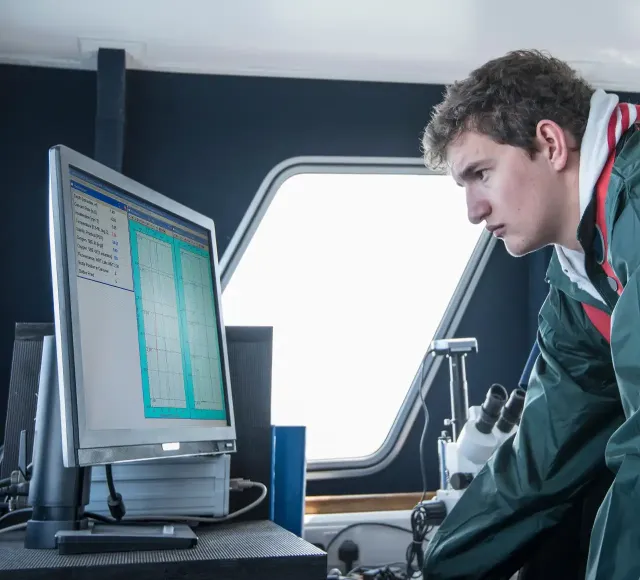 Scientists inspecting data on research ship