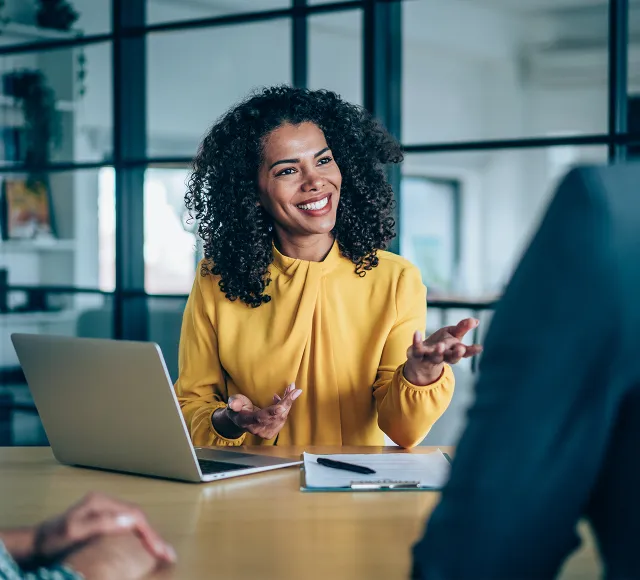 Person in a meeting with a laptop in a conference room.