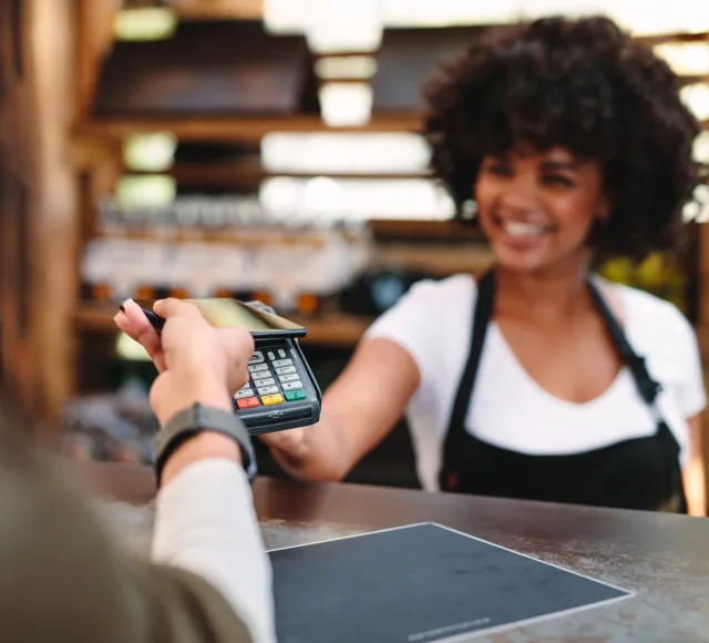 Person making a contactless payment at a store checkout counter.