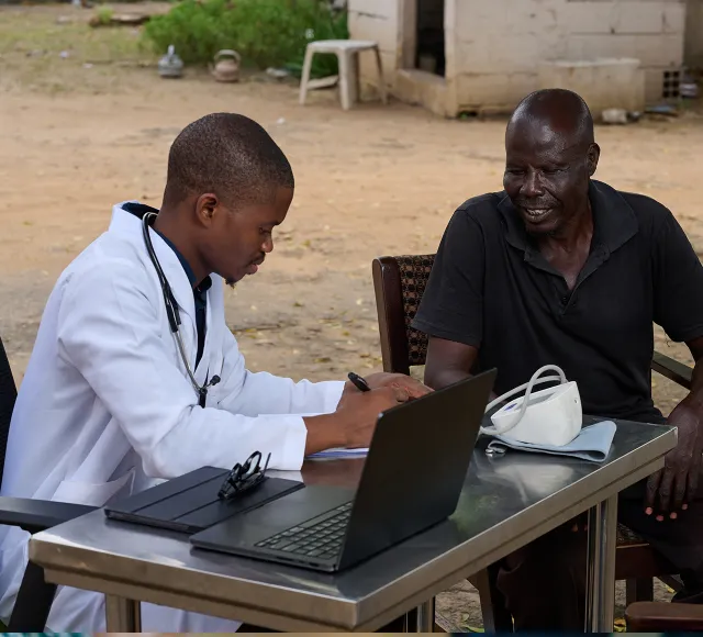 Outdoor medical consultation using a laptop.