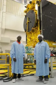 Michael Yeboah y su padre visitando las salas limpias de Thales Alenia Space con el satélite EUTELSAT 21B en construcción