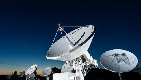 Un groupe d'antennes satellites la nuit au téléport Eutelsat de Paris-Rambouillet