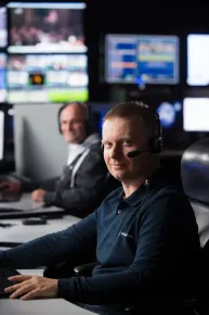 Gros plan d'un membre du personnel souriant, travaillant au téléport de Paris-Rambouillet, supportant la bande passante