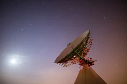 Angle bas d'une antenne satellite la nuit au téléport Eutelsat de Paris-Rambouillet