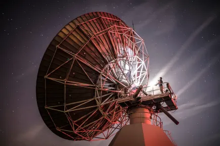 Vue arrière d'une antenne satellite la nuit au téléport Eutelsat de Paris-Rambouillet