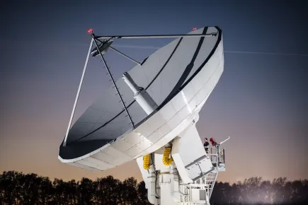 Antenne satellite en fonctionnement, illuminée la nuit à l'échelle humaine au téléport de Eutelsat à Paris-Rambouillet