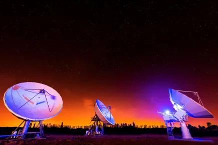 Plusieurs antennes satellites pendant un coucher de soleil orange au téléport Eutelsat de Paris-Rambouillet