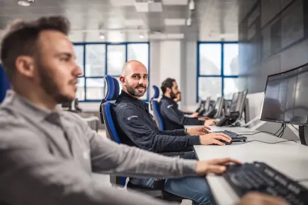 Miembro del equipo operando dentro del telepuerto Eutelsat Skylogic Mediterráneo en Cagliari (Cerdeña), con pantallas en el fondo