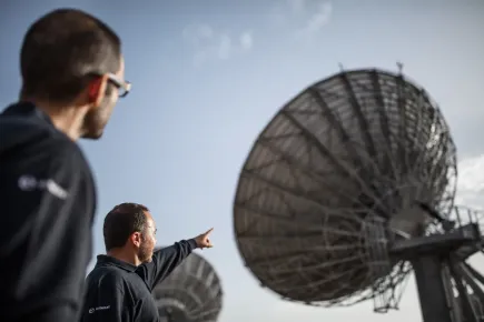 Miembros del equipo señalando una antena satelital en el telepuerto Eutelsat Skylogic Mediterráneo en Cagliari (Cerdeña)