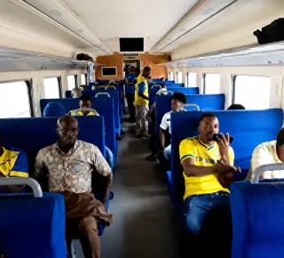 Passengers seated inside a train carriage.