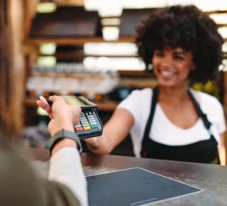 Person making a contactless payment at a store checkout counter.