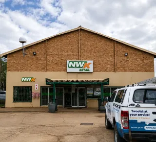 Exterior view of a commercial building with parked vehicles
