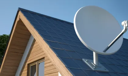 Roof of wooden house in rural location with satellite dish