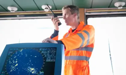 Travailleur à bord du navire sur la passerelle utilisant un talkie-walkie