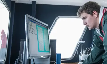 Des scientifiques inspectant des données sur un navire de recherche.