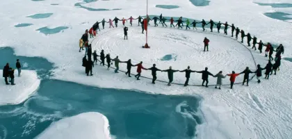 A group of tourists form a human circle and dance through all the time zones.